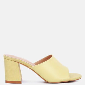 Yellow block heel slip-on sandals with an open toe design. Yellow block heel slip-on sandals with an open toe design and a textured heel.