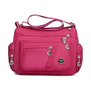 Pink shoulder bag featuring multiple zippered pockets and a detachable strap.