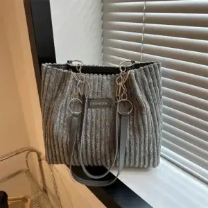 Gray ribbed handbag with chain straps and a label that says 'FASHION'.