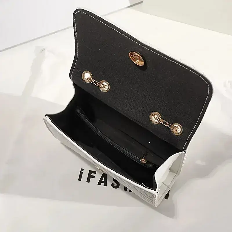 An open white handbag featuring a black interior and gold accents. Open white handbag showing a black interior with a zippered pocket and gold hardware.