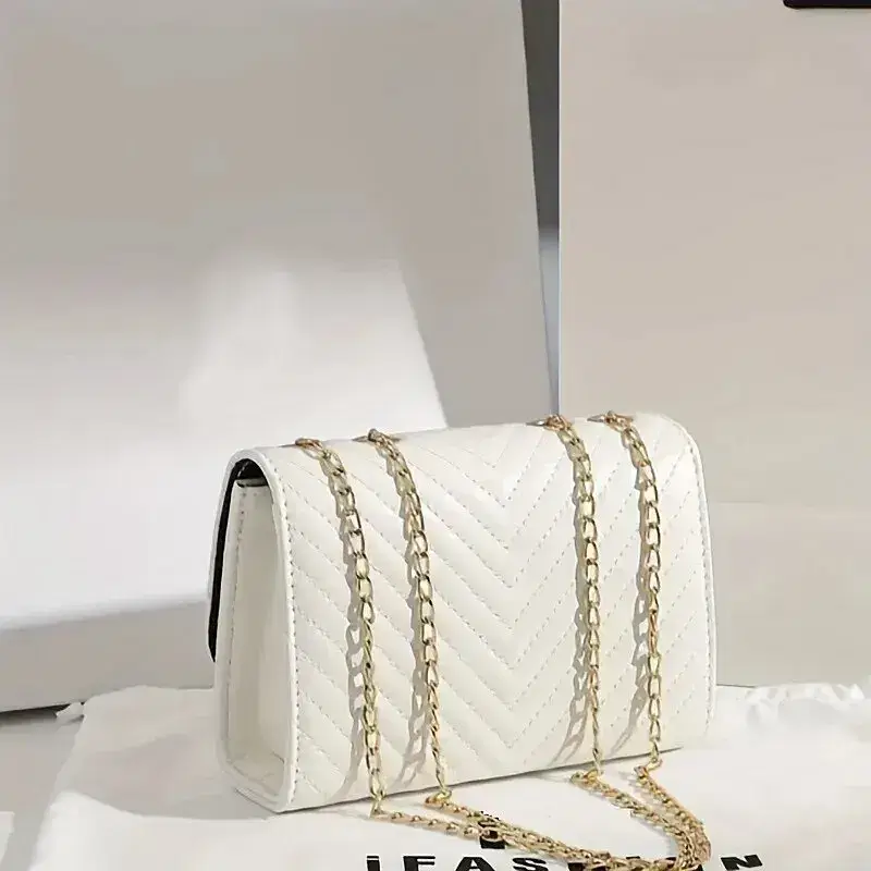 A white quilted handbag with a gold chain strap. White quilted handbag featuring a gold chain strap and a structured design.