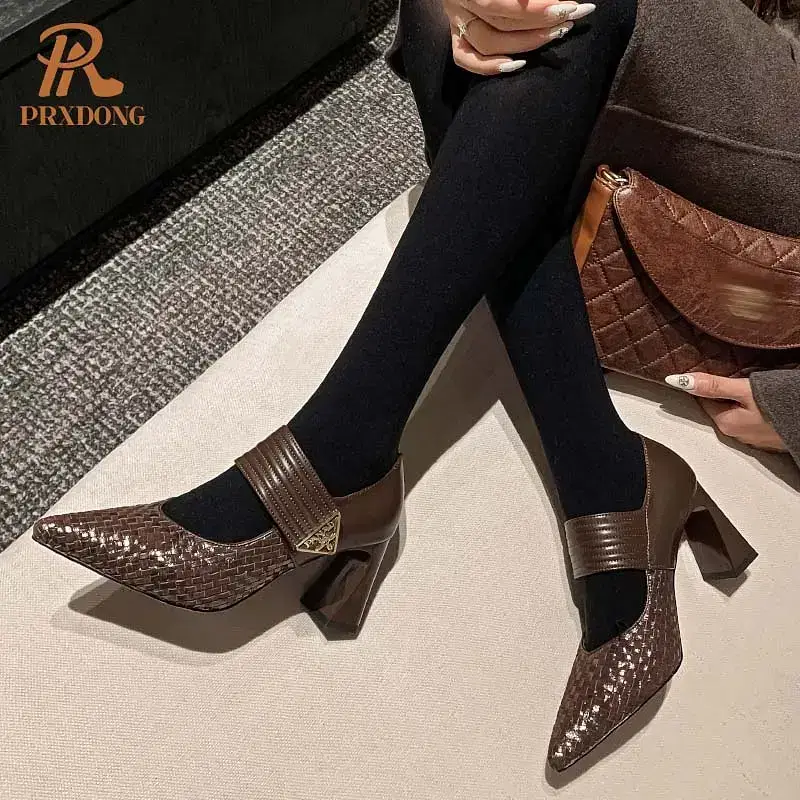 Brown heeled shoes featuring a strap and textured design. Brown heeled shoes with a strap and textured design worn with black tights.